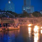 Fires illuminate the faces of the crowd in Waterplace Park during a WaterFire lighting in 2018. Photograph by Jen Bonin.