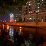 Visitors sitting enjoying the fires at WaterFire. Photograph by Erin Cuddigan.