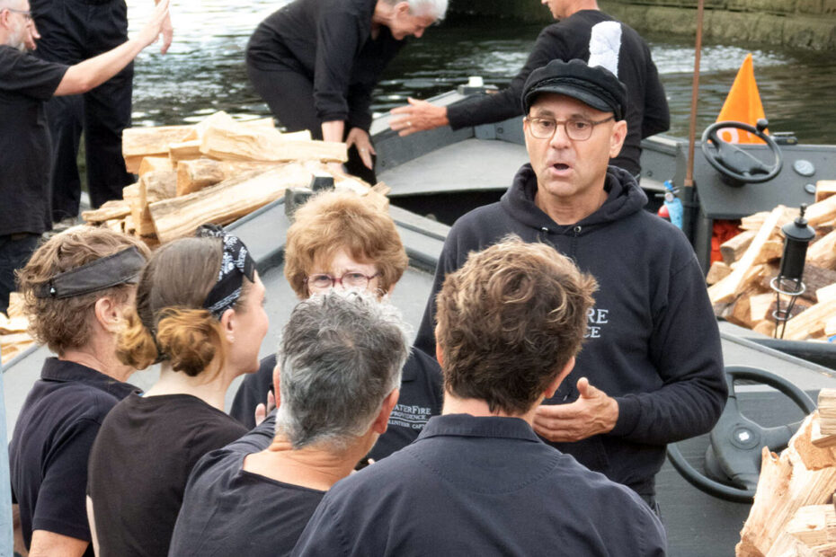 Charlie Stone speaks to other volunteers before a WaterFire event. Photograph by Christian Podzon.