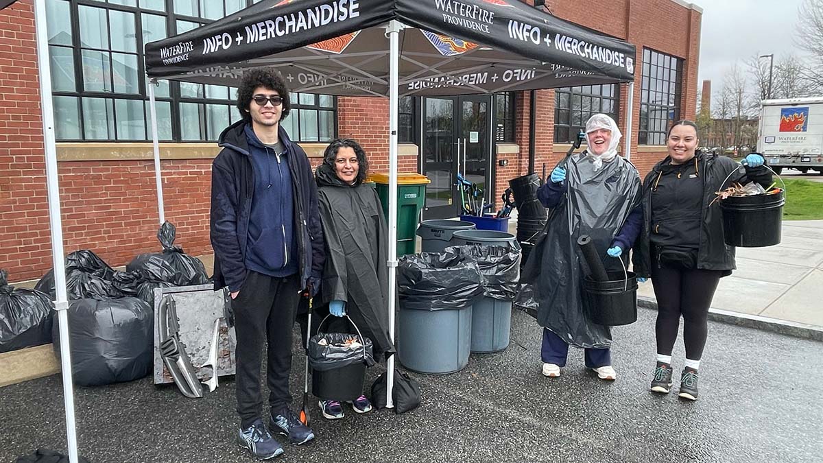 Volunteers, interns, and staff staying dry at our Earth Month Cleanup at the WaterFire Arts Center. Photograph by Laura Duclos.